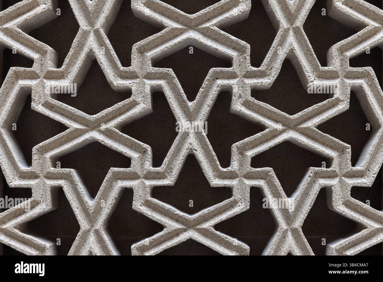 Intricato motivo geometrico arabo caratterizzato da simmetrie interconnesse, che evocano disegni islamici tradizionali, con tonalità neutre di arenaria che creano un cappello Foto Stock