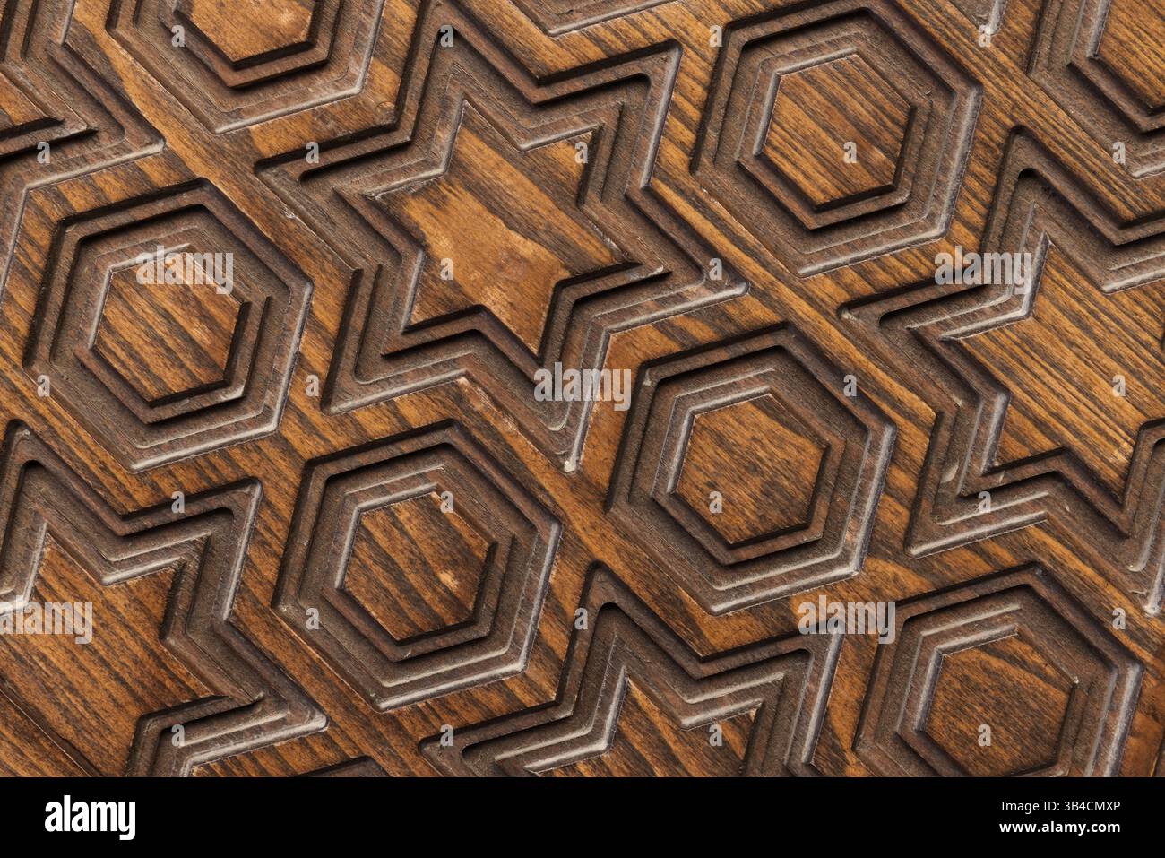 Struttura in legno intagliato con motivi geometrici decorativi di stelle ed esagoni, che mostrano maestria artigianale e artistica adatta al design inspira Foto Stock