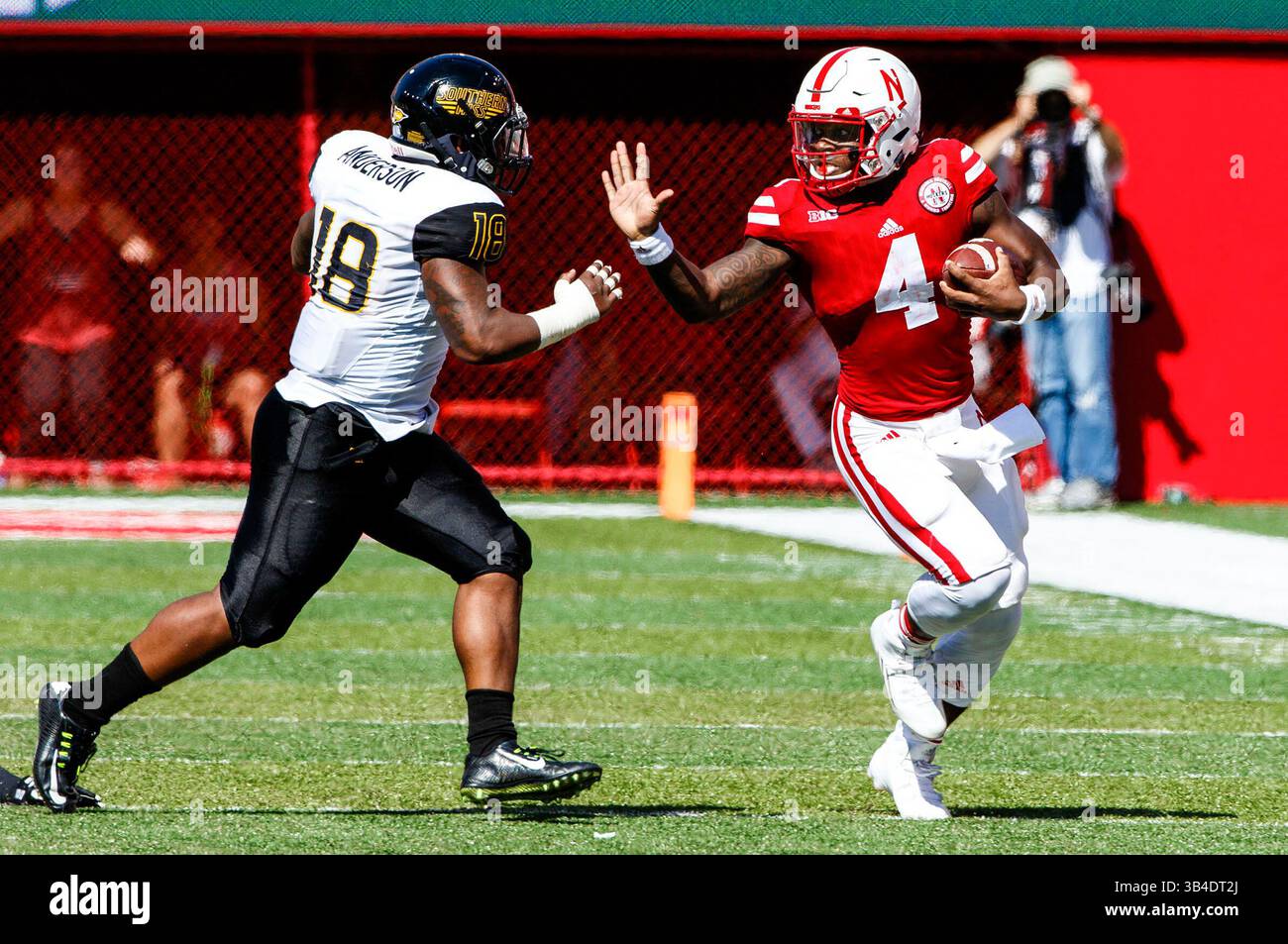 26 settembre 2015 - Lincoln, Nebraska. Stati Uniti - il quarterback dei Nebraska Cornhuskers Tommy Armstrong Jr. #4 corre vicino alla linea laterale e alle braccia rigide il linebacker di Southern Miss Golden Eagles Brian Anderson #18 in azione durante una partita di football della NCAA Division 1 tra i Southern Mississippi Golden Eagles e i Nebraska Cornhuskers al Memorial Stadium di Lincoln, Nebraska...presenza: .Nebraska ha vinto 36-28.presenza: 89.899.Michael Spomer/Cal Sport Media(Credit Image: SM Michael Spomer/Cwire) © ZMA Foto Stock