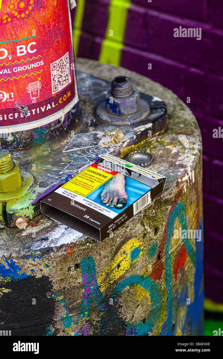 Un'avvertenza grafica sul fumo stampata su un pacchetto di sigarette in un vicolo sul retro di Vancouver Foto Stock
