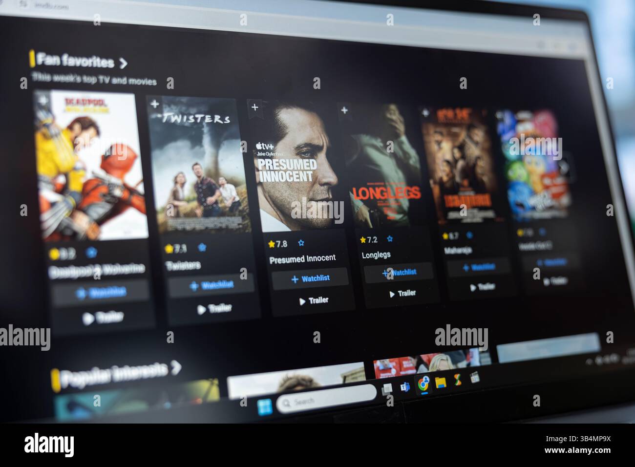 Bucarest, Romania - 30 luglio 2024 - gli appassionati di cinema sfogliano l'elenco IMDb On Demand, controllando le valutazioni e la recensione del cast o della critica prima di guardare un film. Cinephile cerca la valutazione del film. Foto Stock