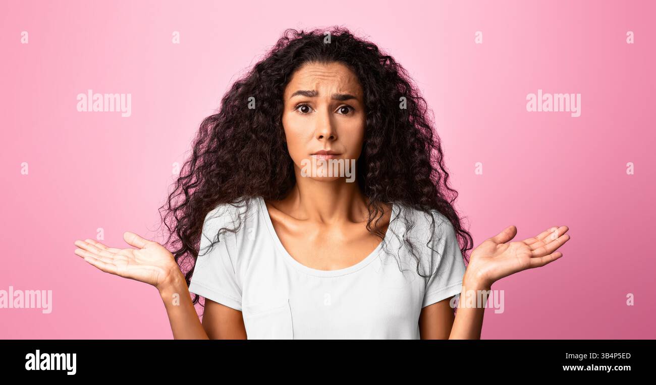 Non lo so. Giovane donna interessata che si è infranagliata le spalle con mani spalmate Foto Stock