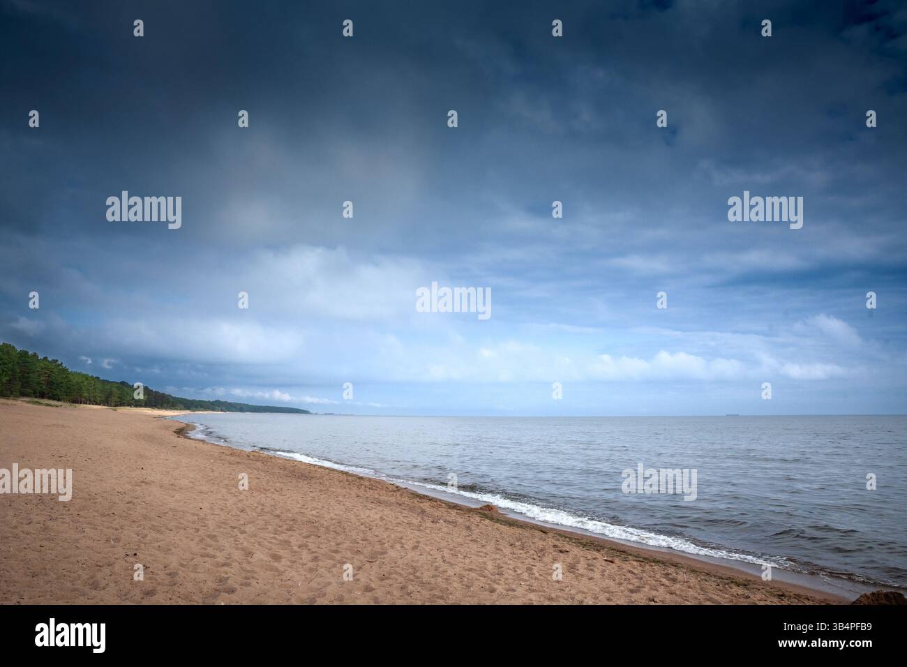Ampia e vuota striscia di sabbia color miele sul Mar Baltico sotto le spettacolari nuvole estive della spiaggia di Saulkrasti (Saulkrastu Pludmale), un tranquillo Vidzeme co Foto Stock