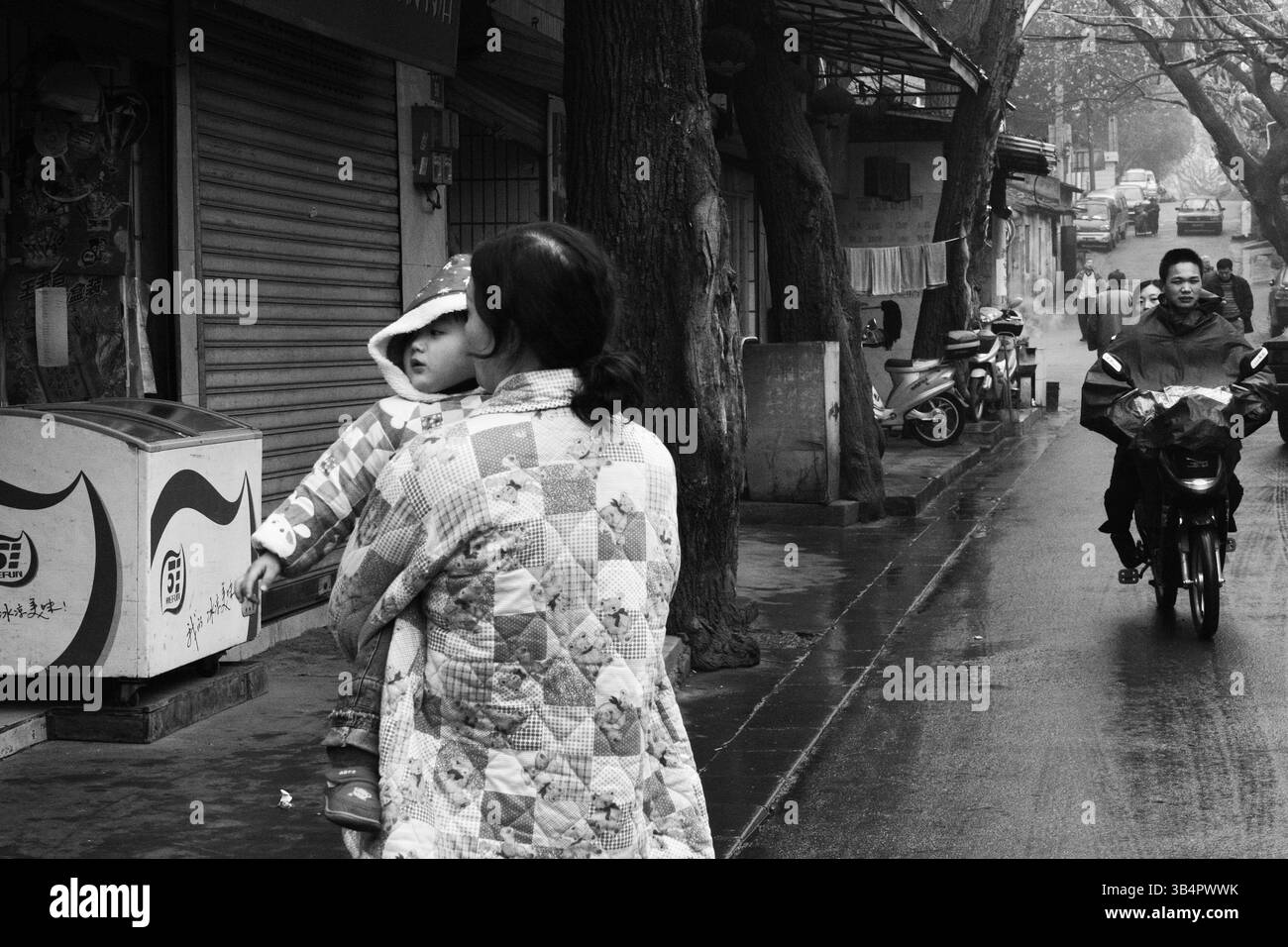 Rainy Day Street Scene a Hangzhou, Cina con donna e bambino, 2009 anni, Zhejiang, Cina Foto Stock