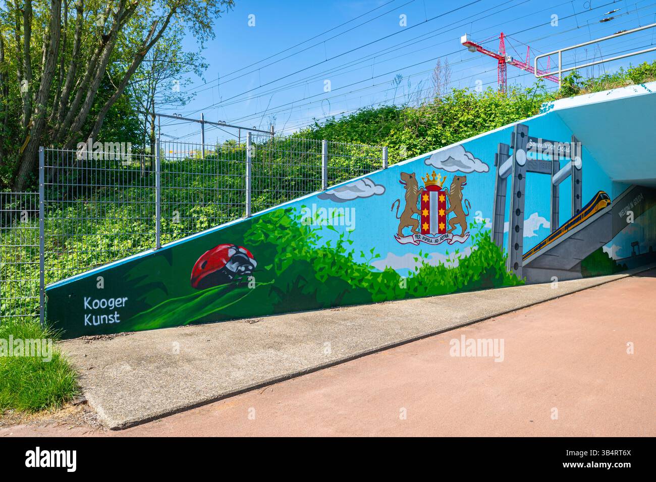 Graffiti colorati sulla parete di un tunnel ferroviario vicino a Winterdijk a Gouda, Paesi Bassi. Comprende un uccello coccinello, lo stemma di Gouda e un ponte ferroviario. Foto Stock