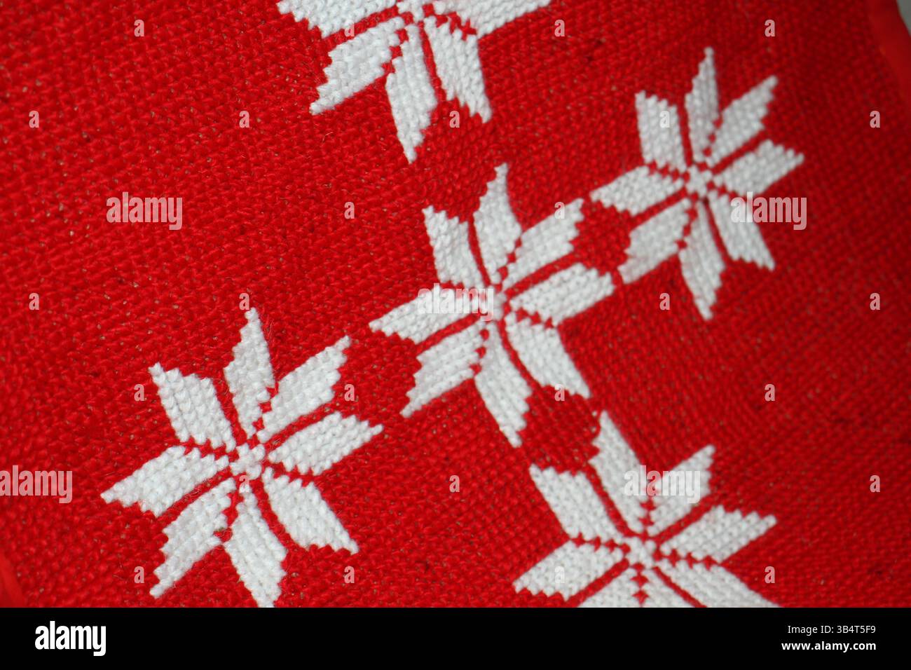 Tappetino realizzato a mano di colore rosso con motivo floreale bianco, il tappetino è realizzato in lana, cotone, filo, stoffa, ecc. Foto Stock