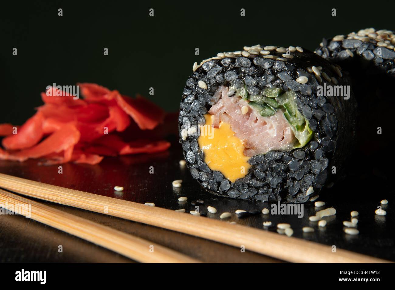Riso nero. Panini con formaggio, prosciutto e cetriolo. Bastoni e zenzero vengono leccati vicino alla terra. Foto Stock