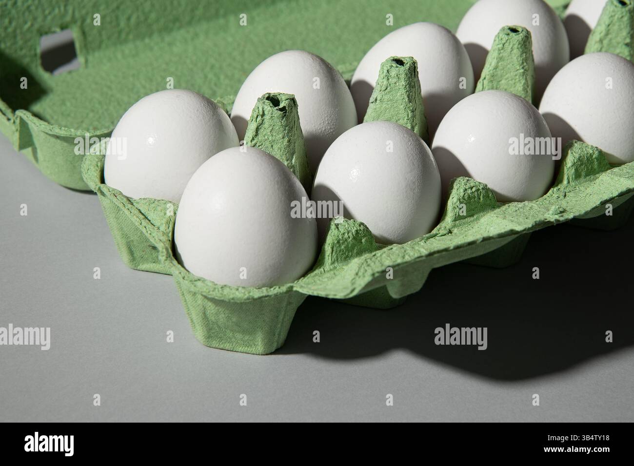 Scatola di uovo verde di cartone su uno sfondo grigio, un sacco di uova sono nella scatola. Foto Stock