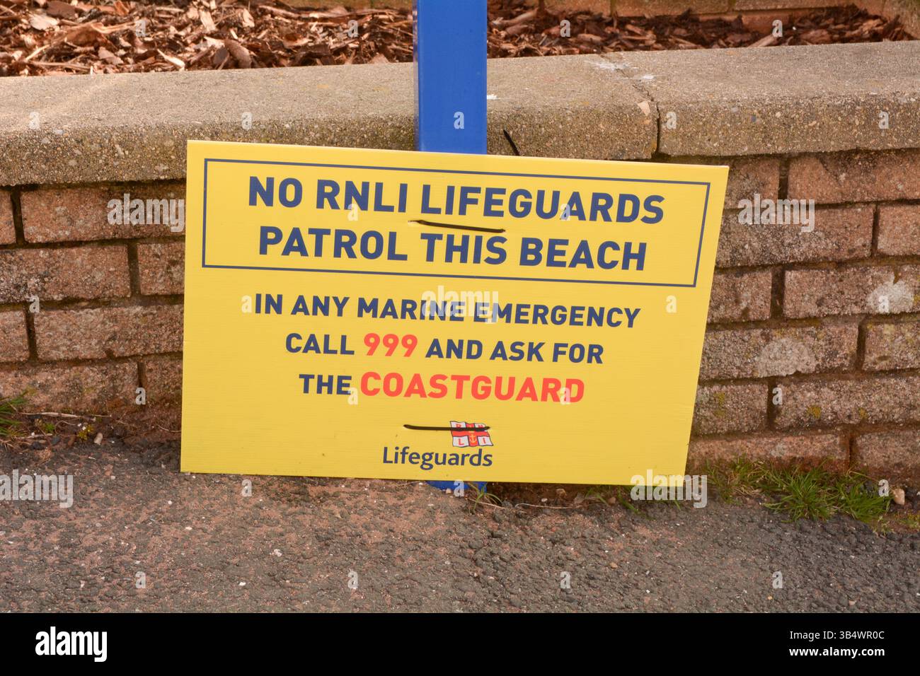 Cartello con scritto 'No RNLI bagnini pattuglia questa spiaggia' 'in qualsiasi emergenza marina chiama il 999 e chiedi della guardia costiera' a Teignmouth, Devon, Inghilterra Foto Stock