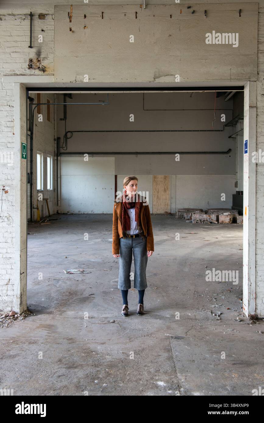 Ritratti donna di genere, che indossa la moda maschile all'interno di un ambiente industriale. Tilburg, Paesi Bassi. MR=SÌ Foto Stock