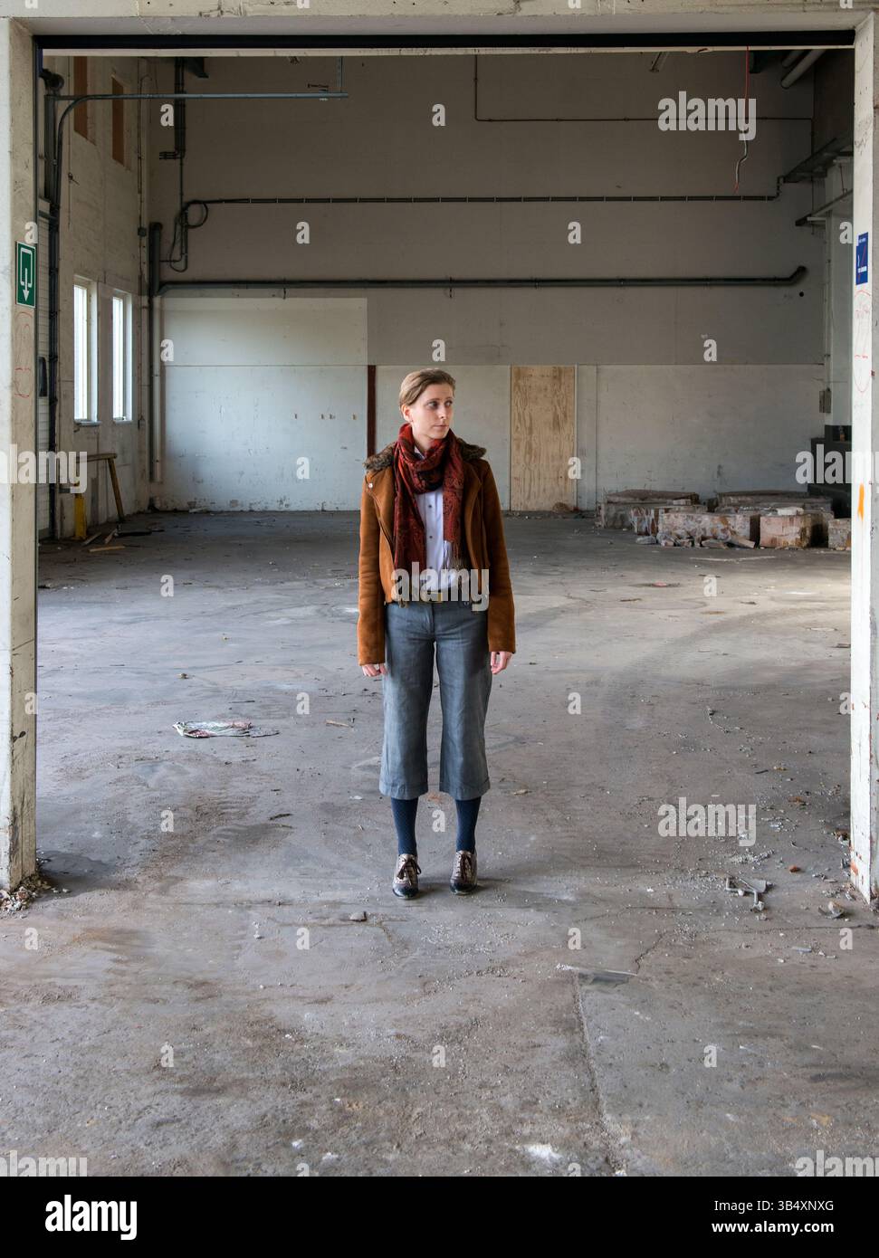 Ritratti donna di genere, che indossa la moda maschile all'interno di un ambiente industriale. Tilburg, Paesi Bassi. MR=SÌ Foto Stock