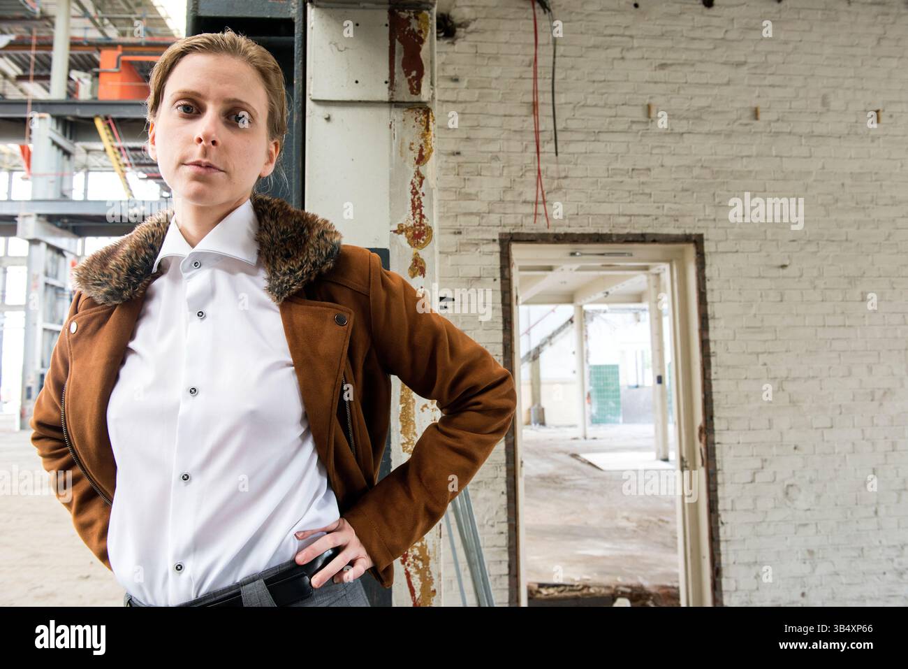 Ritratti donna di genere, che indossa la moda maschile all'interno di un ambiente industriale. Tilburg, Paesi Bassi. MR=SÌ Foto Stock