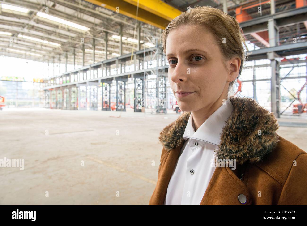 Ritratti donna di genere, che indossa la moda maschile all'interno di un ambiente industriale. Tilburg, Paesi Bassi. MR=SÌ Foto Stock