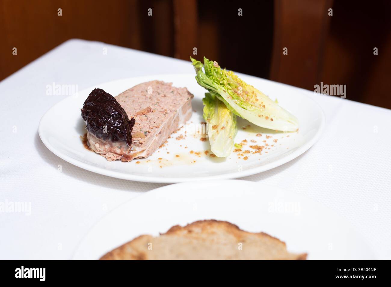 Elegante polpettone: Antipasto gourmet con contorno scuro e lattuga romagina Foto Stock