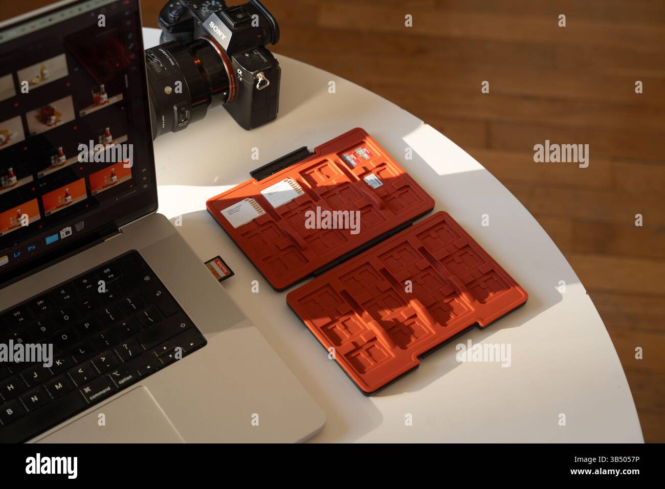 Photograph's Digital Workspace (spazio di lavoro digitale del fotografo): Fotocamera, laptop e schede di memoria in impostazione editing Foto Stock