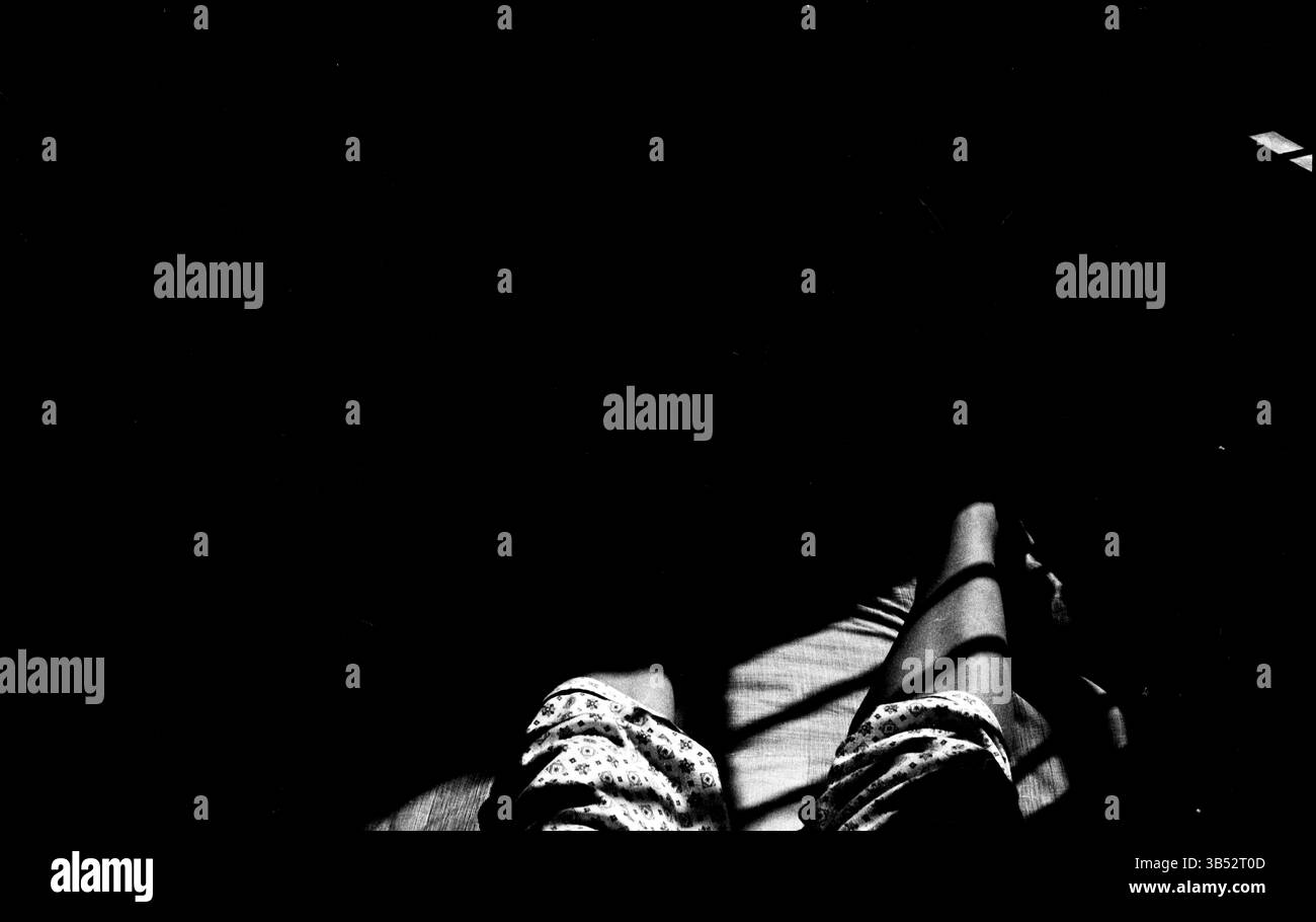 Momenti rilassanti in ombre tenui mettono in risalto la bellezza di ambienti interni tranquilli: Luce soffusa e ombre sulla forma umana – Fotografia minimalista in bianco e nero Foto Stock