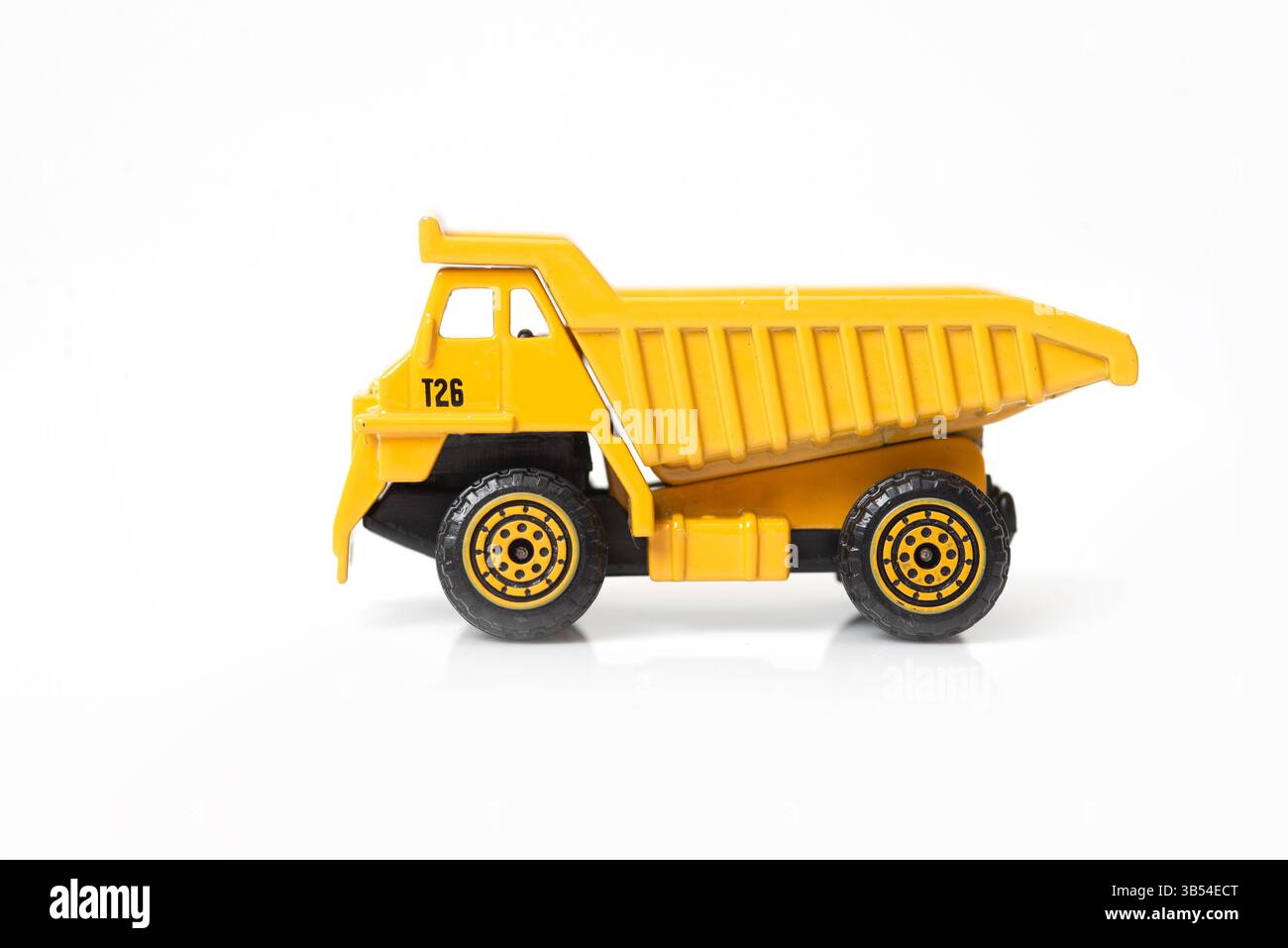 Un camion giocattolo giallo con ruote dettagliate e un design semplice su sfondo bianco. Foto Stock