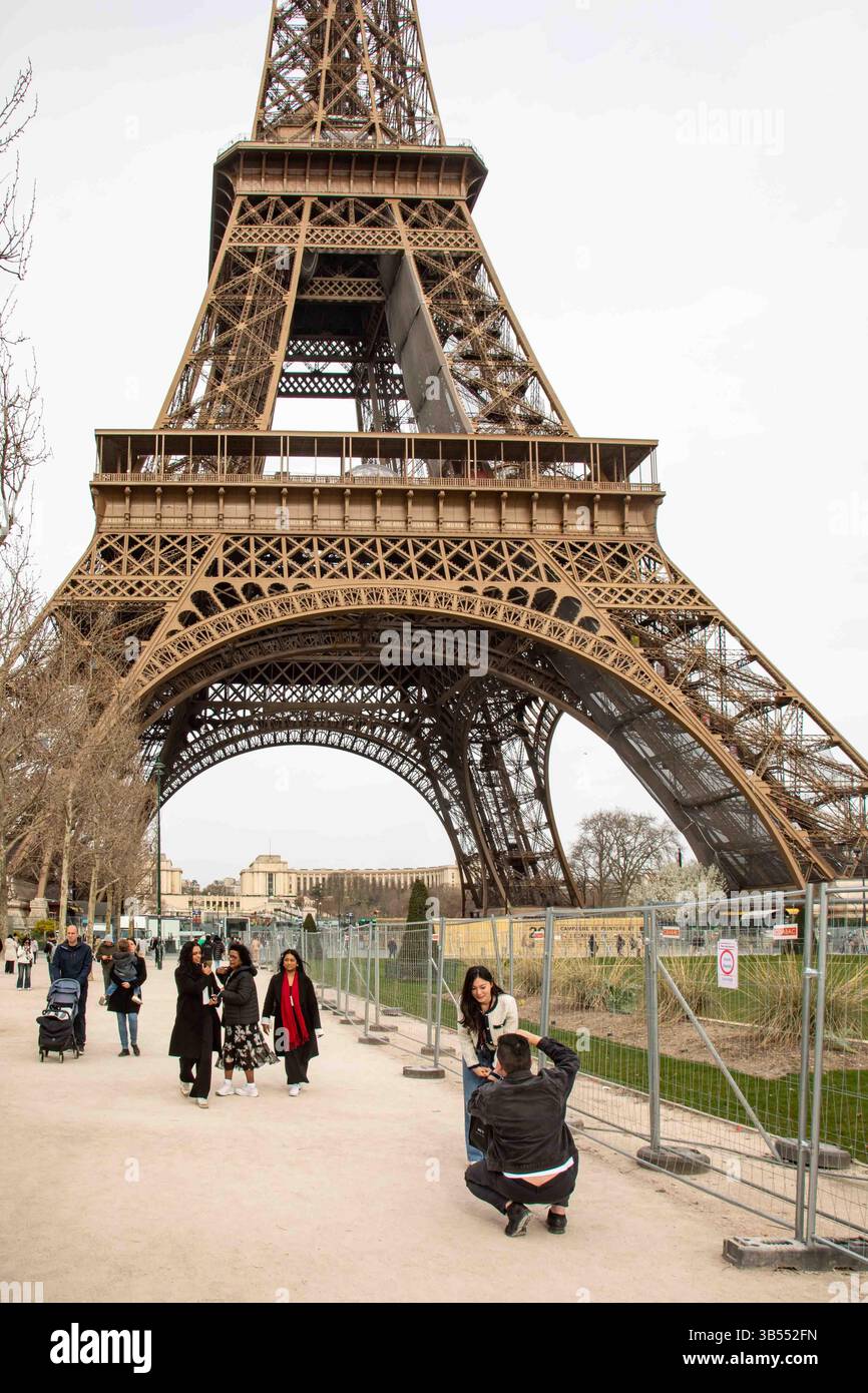 Turisti che scattano foto su Champ de Mars con la Torre Eiffel sullo sfondo a Parigi, Francia Foto Stock