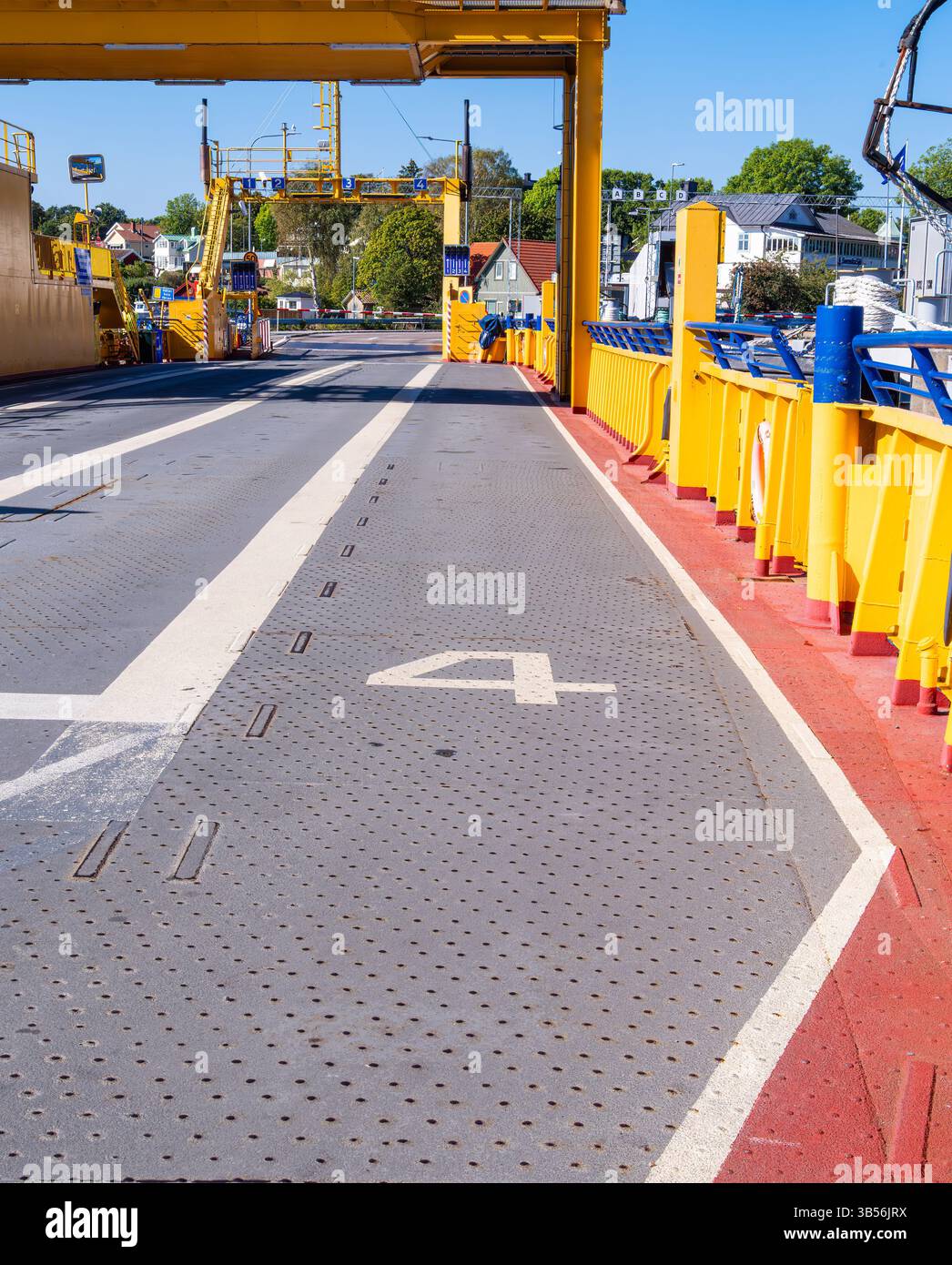 Stoccolma, Svezia - 6 settembre 2024: Ponte dei traghetti vuoto con corsie segnalate e vivaci ringhiere gialle, giorno di sole. Foto Stock