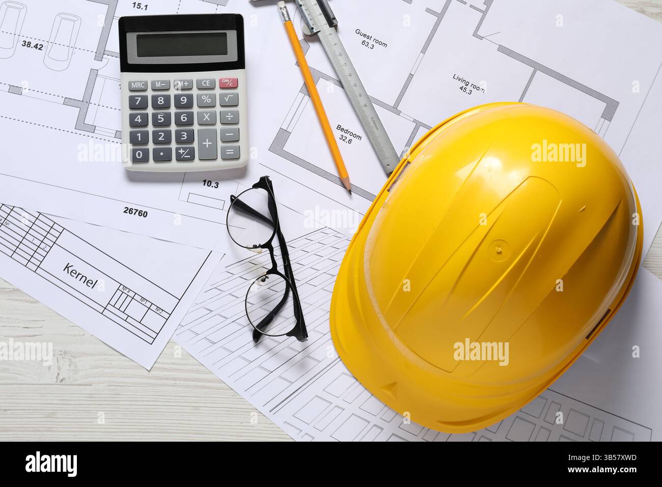 Diversi disegni architettonici, elmetto, matita, calibro a corsoio, calcolatrice e vetri su tavolo in legno chiaro, piatto Foto Stock