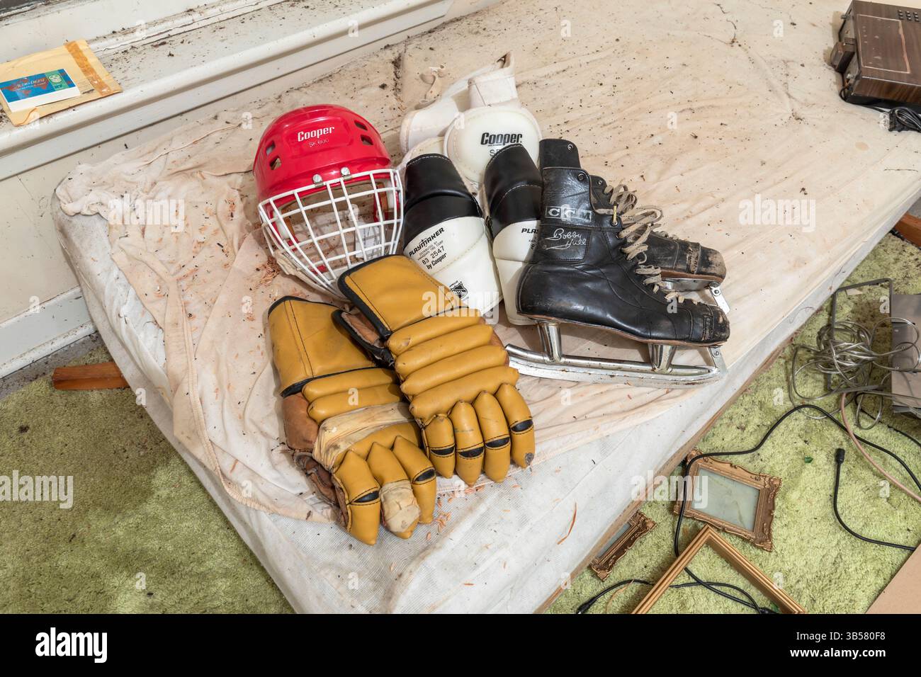 Attrezzatura vintage per hockey su ghiaccio all'interno di una casa abbandonata. Questa casa è stata demolita da allora Foto Stock