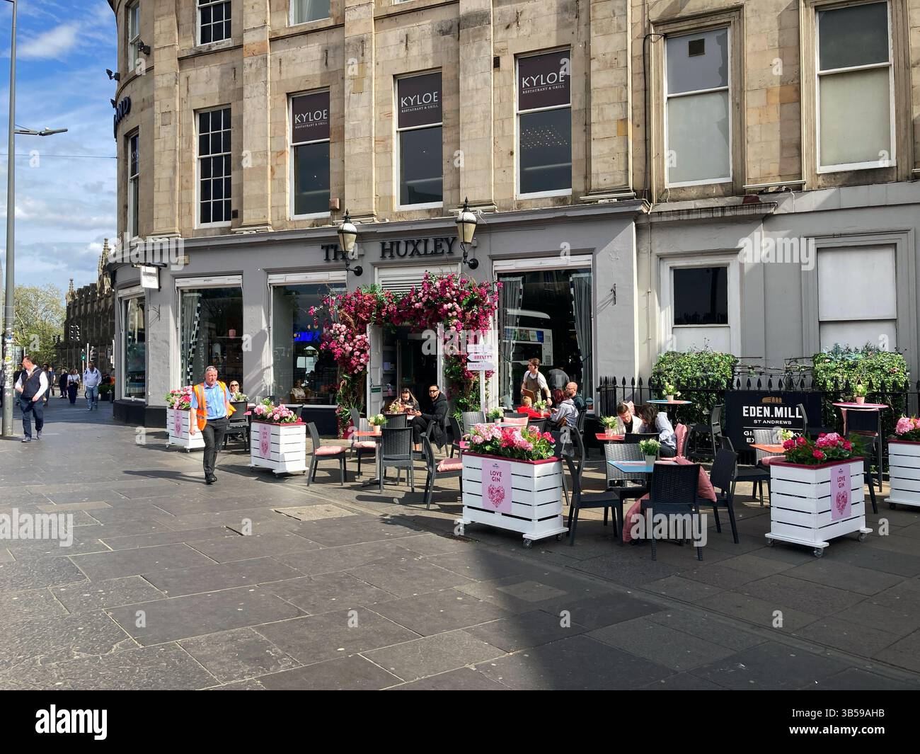 L'Huxley, visto da Shandwick Place, con i clienti che si godono il sole ai tavoli all'aperto, Edimburgo, Scozia - Immagine stock catturata con smartphone