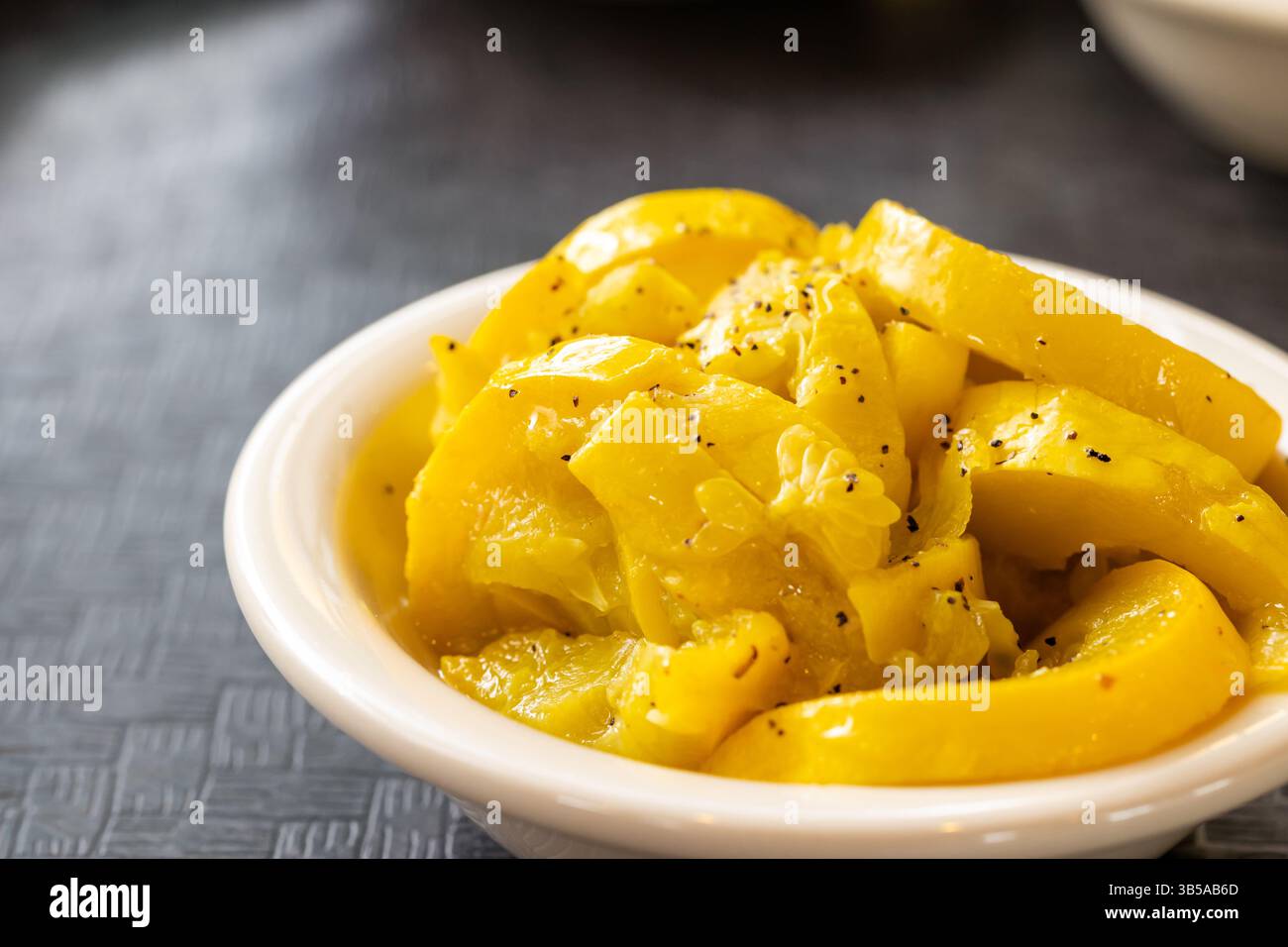 Primo piano di zucca gialla cotta nel recipiente Foto Stock