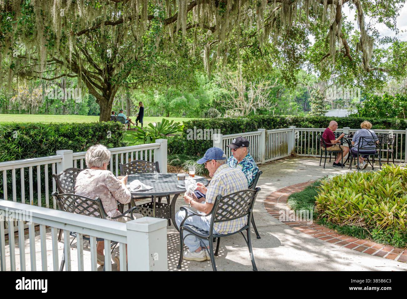 Orlando Florida, Harry P Leu Gardens, giardino botanico, coppia di uomini anziani, patio all'aperto, posti a sedere sul cortile, persone che si rilassano, mangiano Foto Stock
