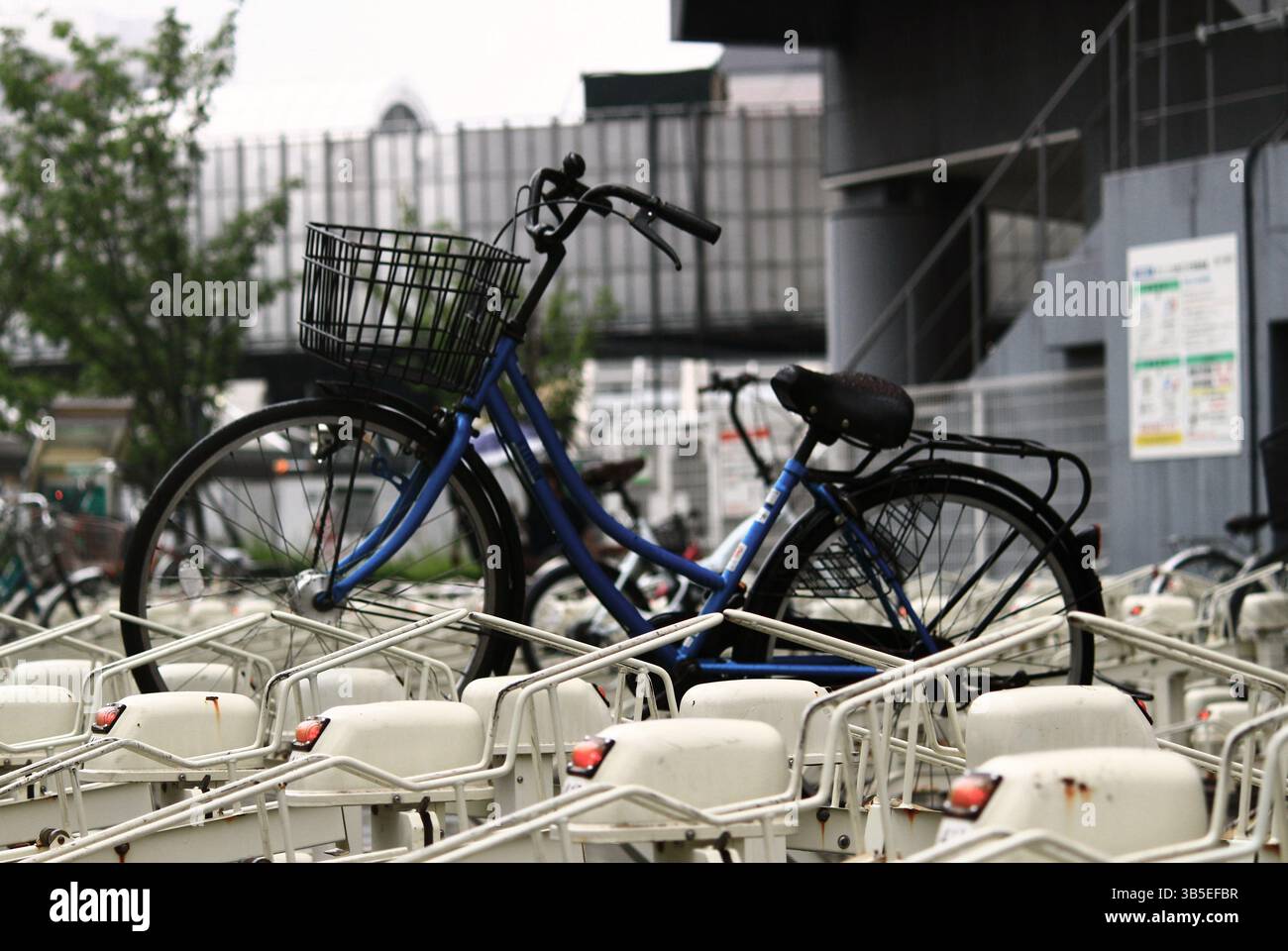 Scene di tutti i giorni in Giappone Una bicicletta lasciata dietro in un parcheggio per biciclette Foto Stock