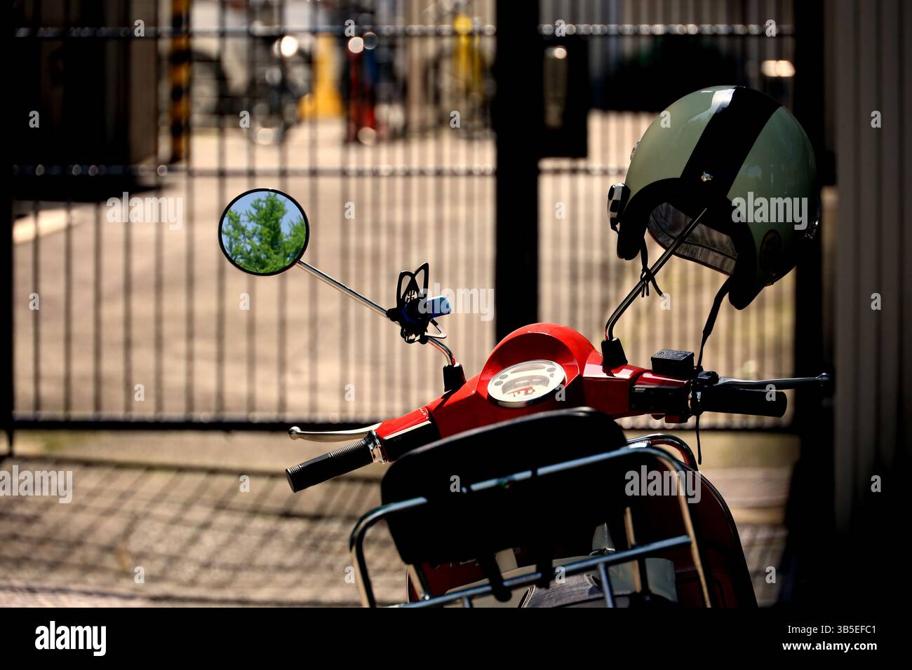 Scene di tutti i giorni in Giappone Uno scooter rosso parcheggiato in un vicolo Foto Stock