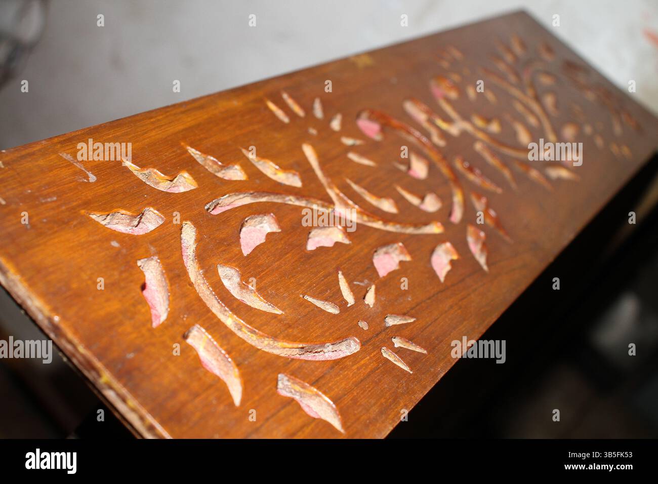 Oggetto in legno con disegno floreale intagliato a mano, la superficie sembra parte di un armonium. Foto Stock