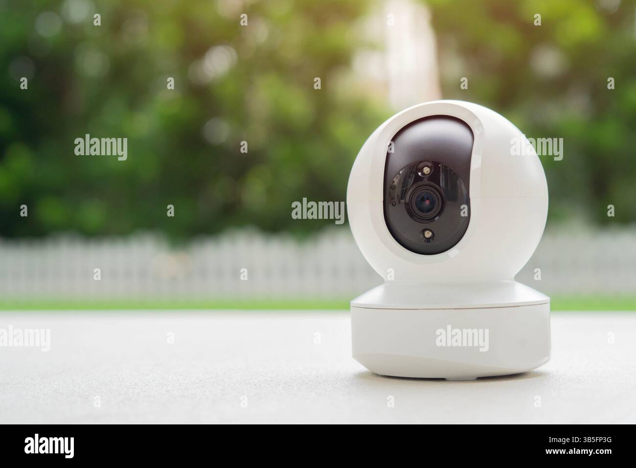 La mini telecamera di sicurezza CCTV funziona nelle vicinanze dello sfondo sfocato della casa. Copia spazio, messa a fuoco selettiva. Foto Stock