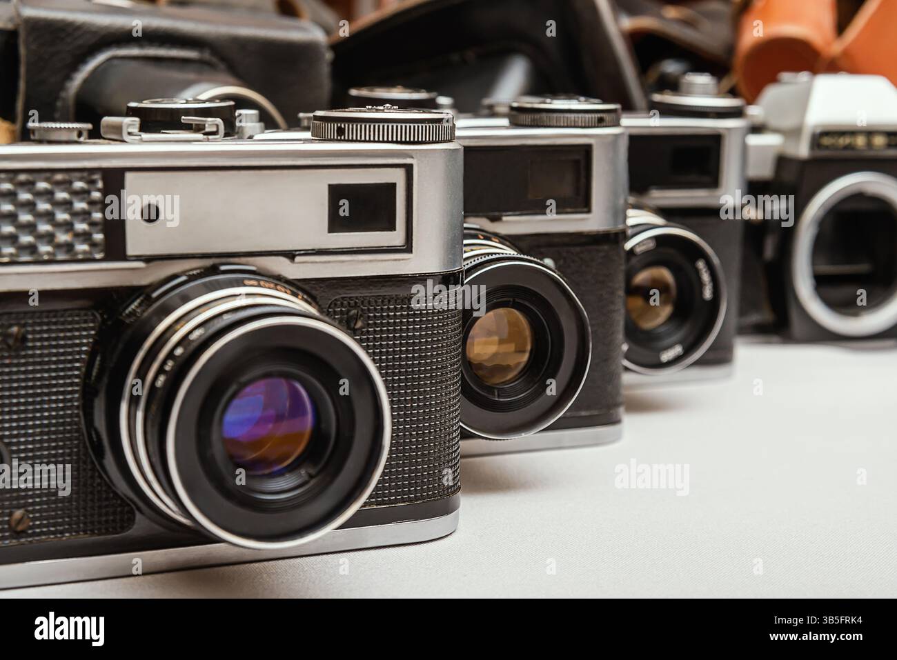 La collezione di varie videocamere usate e custodie in pelle illustra l'appeal e la maestria senza tempo delle apparecchiature fotografiche analogiche. Foto Stock