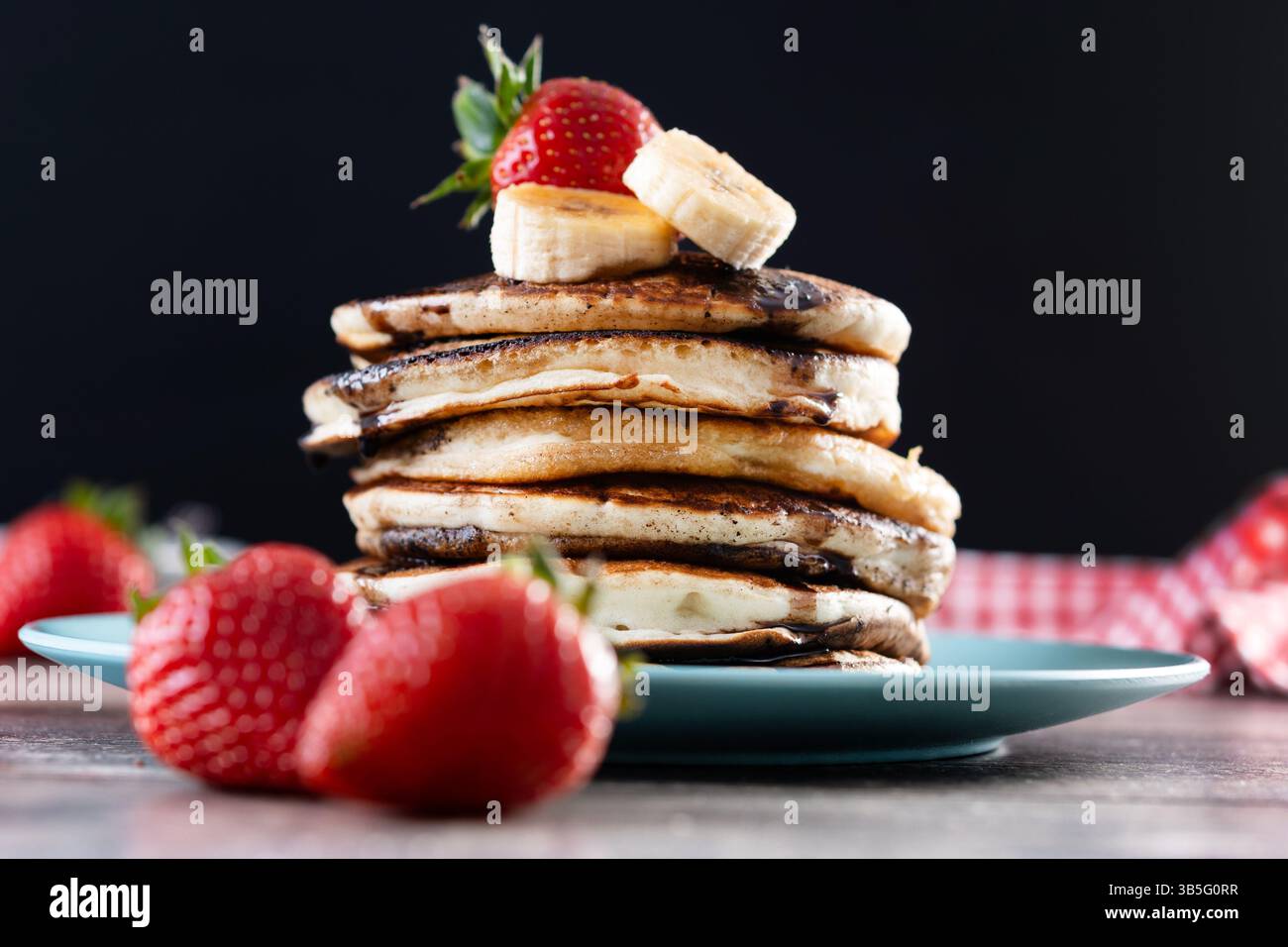 Pancake con cioccolato e frutta su un tavolo di legno Foto Stock