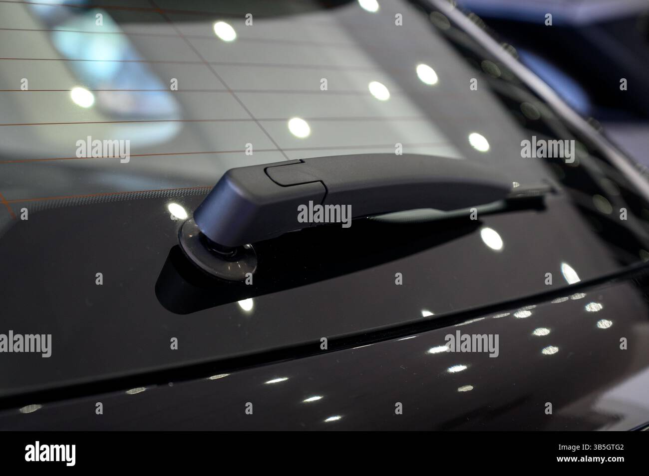 Tergilunotto dell'auto. Primo piano dei tergicristalli posteriori su una vettura nuova. Vista posteriore dell'auto nera con tergilunotto Foto Stock Tergilunotto dell'auto. Primo piano dei tergicristalli posteriori su una vettura nuova. Vista posteriore dell'auto nera con tergilunotto Foto Stock