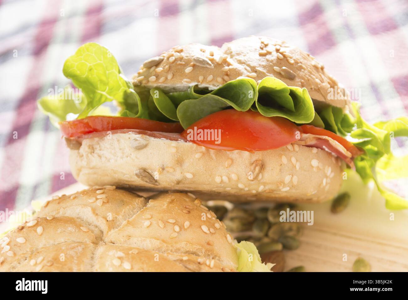 Sandwich freschi con carne affumicata, formaggio, lattuga e pomodoro con fatti in casa ketchup disposti con mandorle e semi di zucca Foto Stock