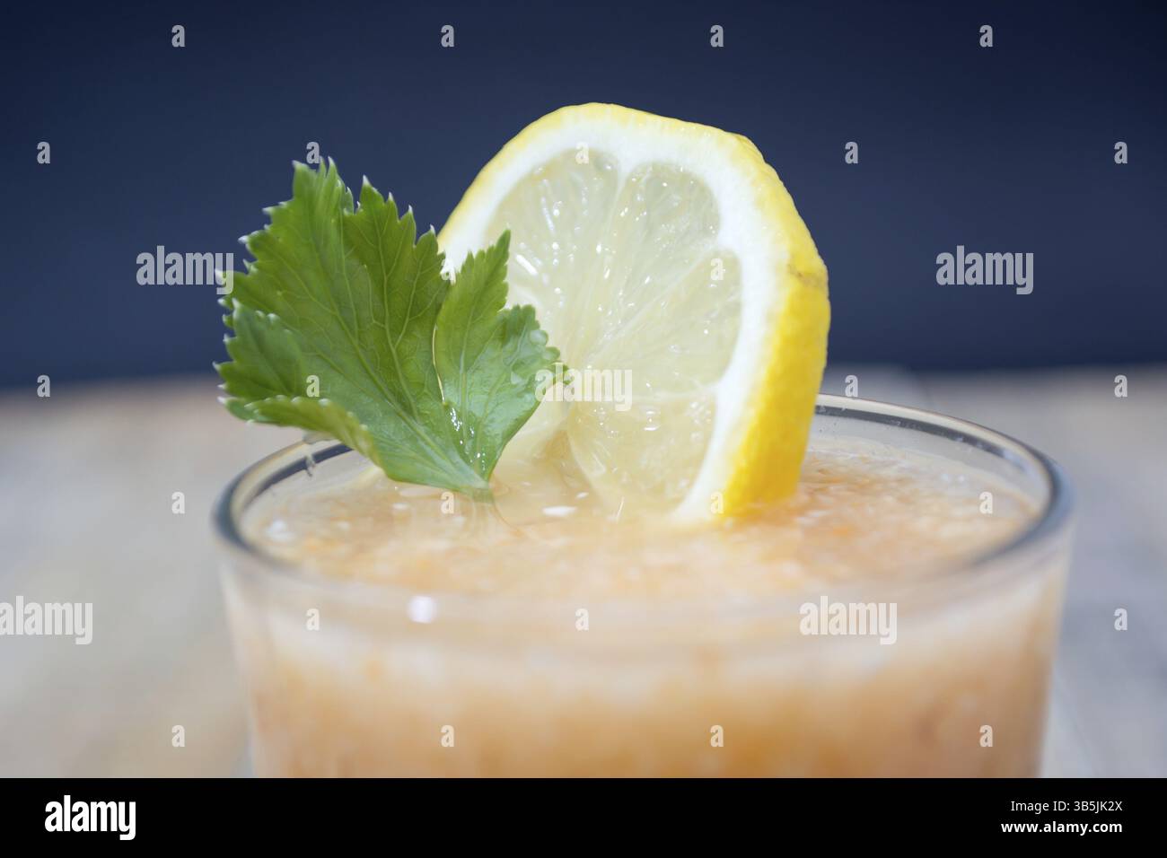 Limonata Fresca con zenzero decorato con Verde foglie di sedano e limone su sfondo scuro Foto Stock
