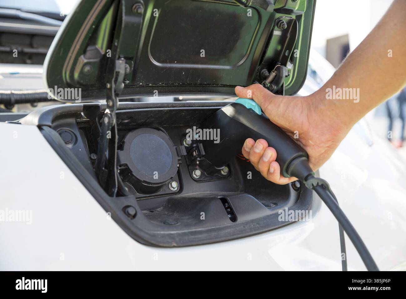 Auto elettrica di carica. Il veicolo elettrico stazione di carica. Mano umana pluging nel caricabatterie. Un auto elettrica è un automobile che è spinto da una Foto Stock