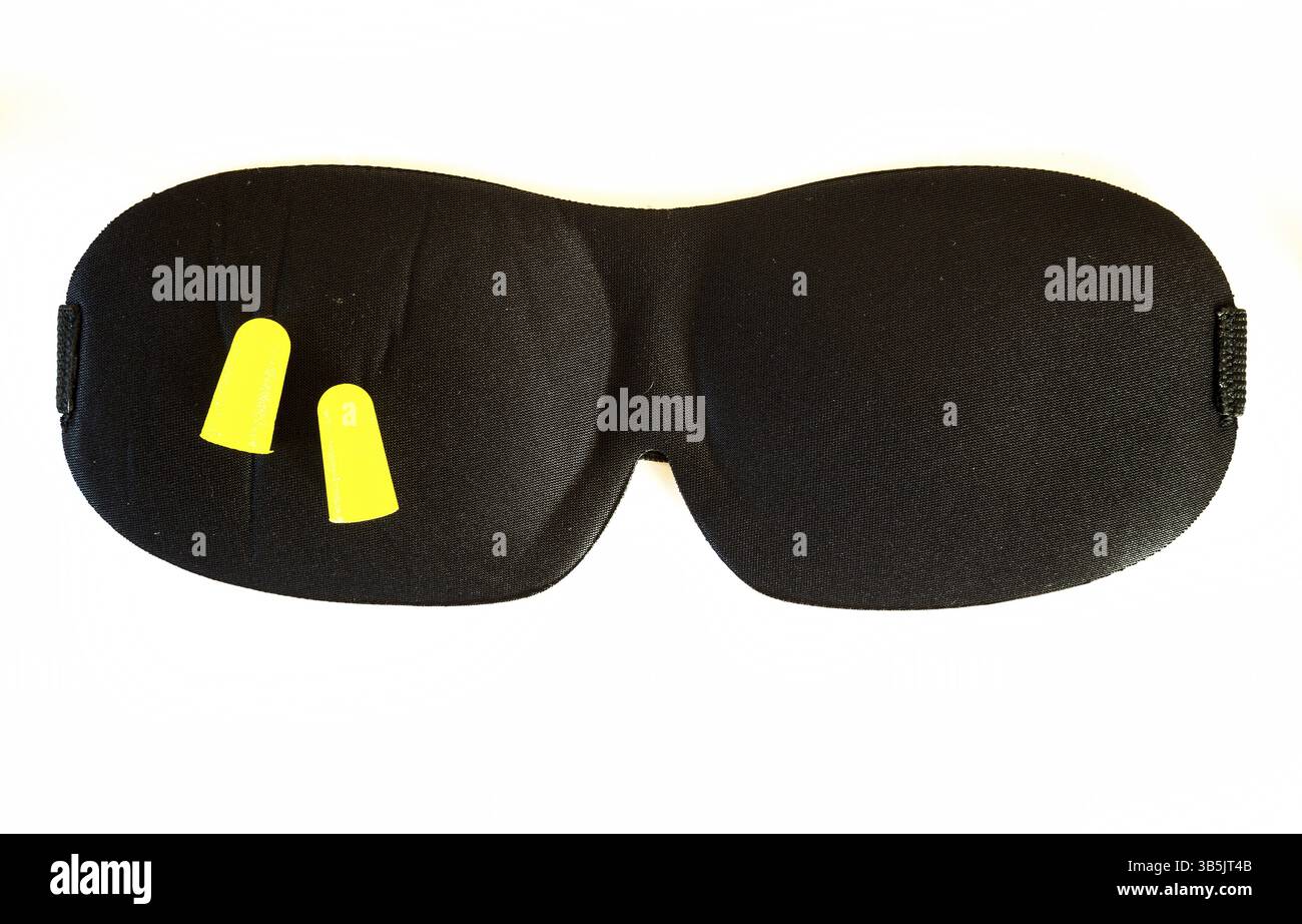 Maschera dormiente nera con tappi auricolari gialli isolati su sfondo bianco. Ripresa in studio Foto Stock