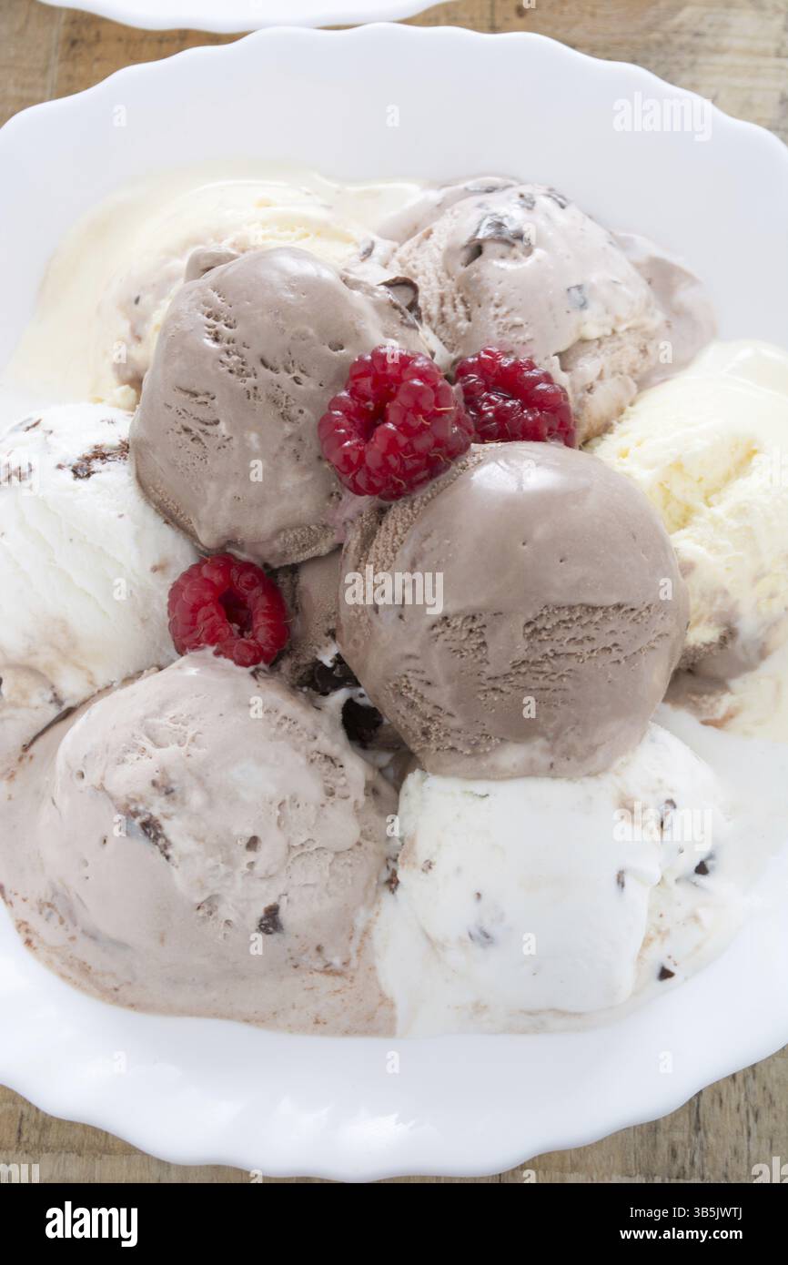 Palline di gelato al cioccolato nella piastra bianca ai lamponi Foto Stock