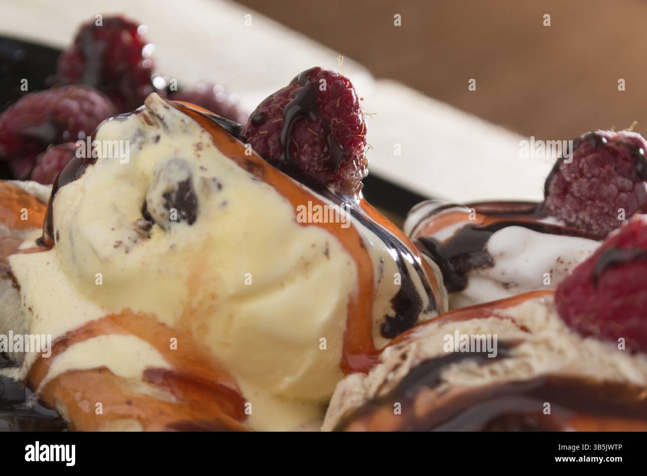 Fresche, golden pancake con frutta e crema su una piastra nera con sfondo sfocato Foto Stock