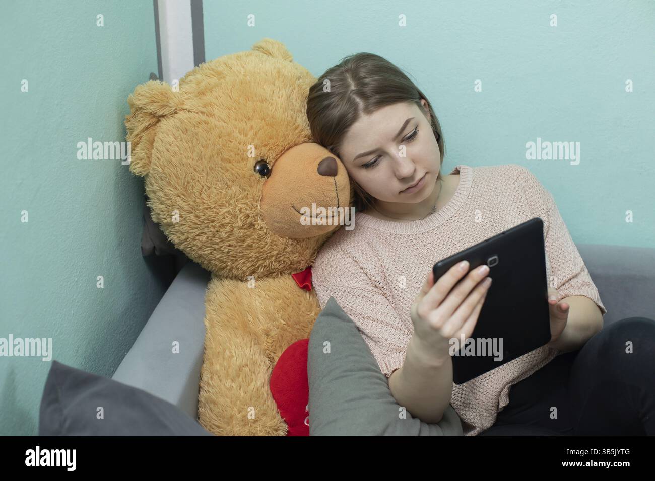 Un'adolescente con il suo amato compagno di peluche cerca di studiare per l'esame di matricola Foto Stock