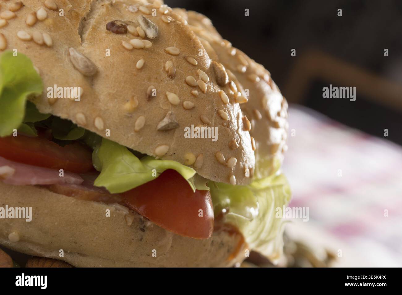 Sandwich freschi con carne affumicata, formaggio, lattuga e pomodoro con fatti in casa ketchup disposti con mandorle e semi di zucca Foto Stock