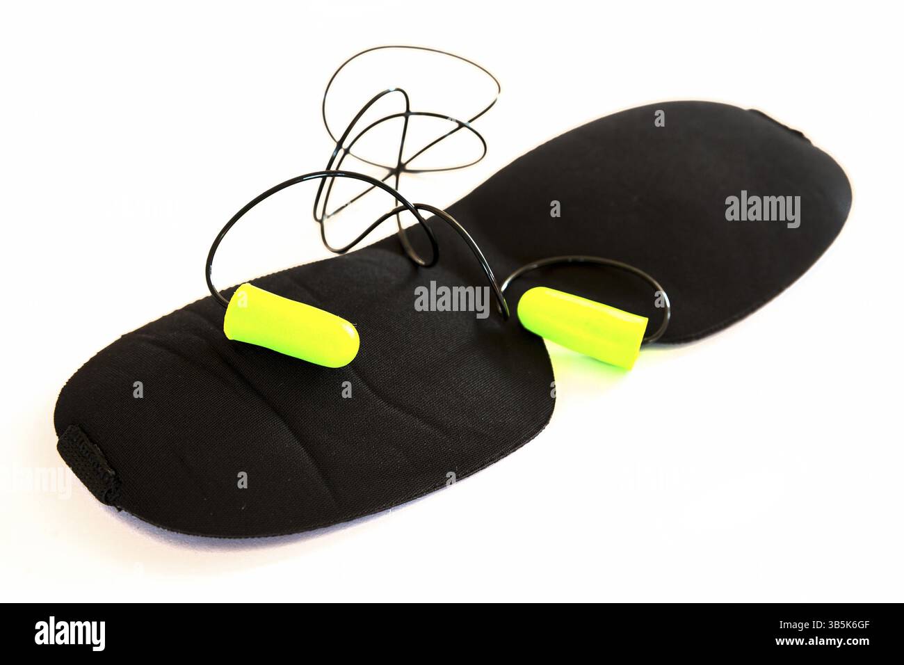 Maschera dormiente nera con tappi auricolari verdi isolati su sfondo bianco. Ripresa in studio Foto Stock