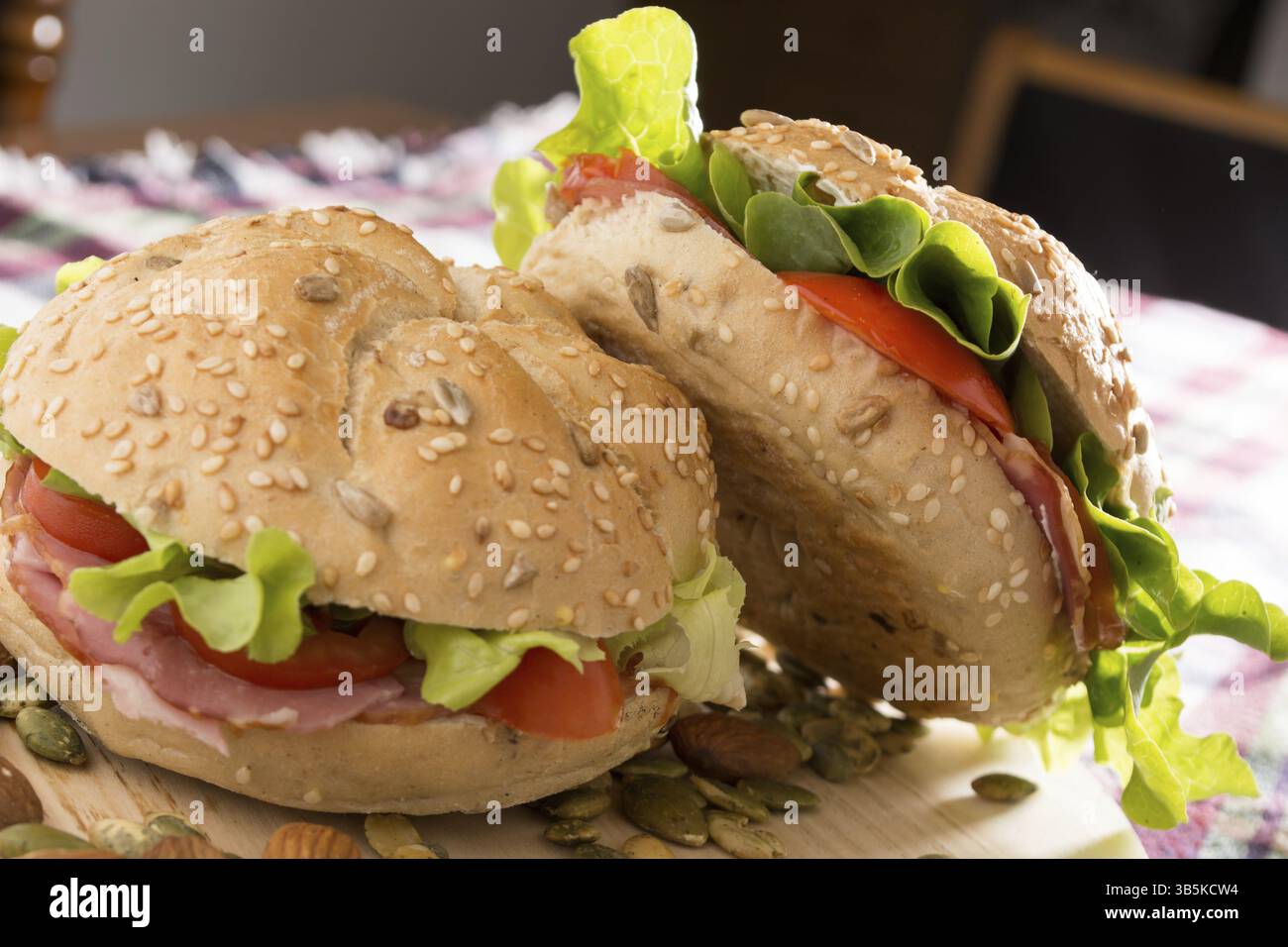Sandwich freschi con carne affumicata, formaggio, lattuga e pomodoro con fatti in casa ketchup disposti con mandorle e semi di zucca Foto Stock