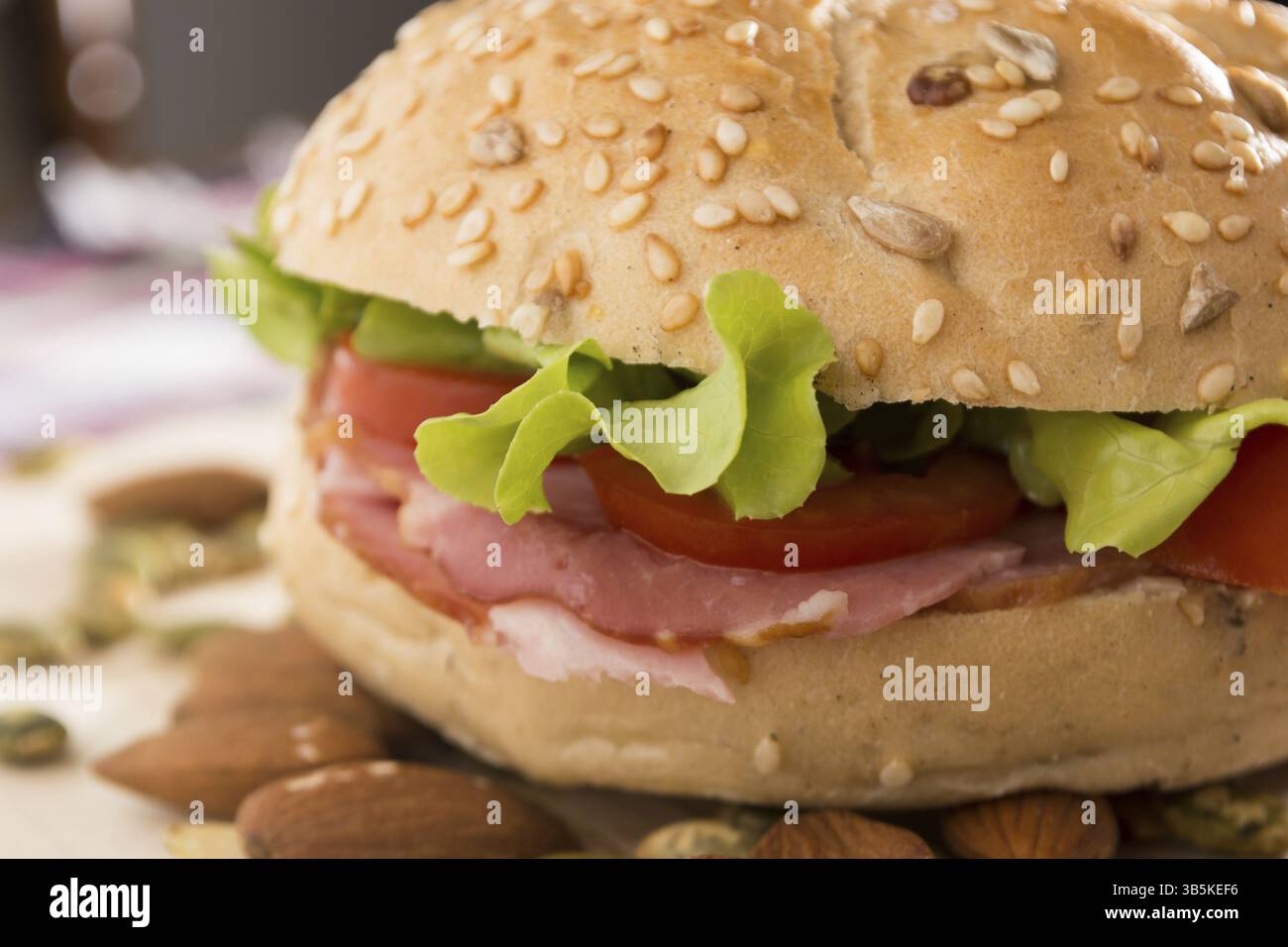 Sandwich freschi con carne affumicata, formaggio, lattuga e pomodoro con fatti in casa ketchup disposti con mandorle e semi di zucca Foto Stock