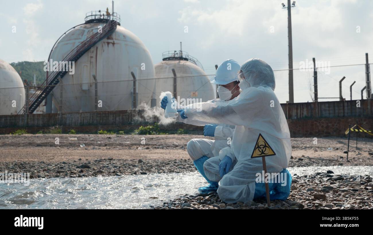 Ecologista campionamento di acqua di sostanze chimiche tossiche dallo schermo a sfioramento del fiume su tablet digitale Foto Stock