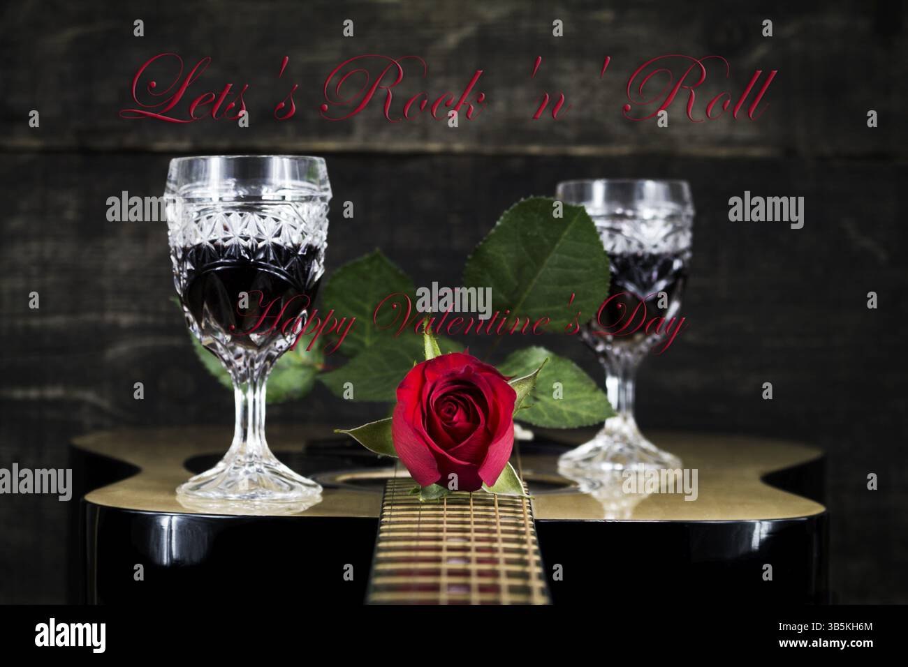 Red Rose e bicchieri di vino in appoggio su una chitarra acustica con Sign consente al Rock And Roll. Il giorno di San Valentino concetto Foto Stock
