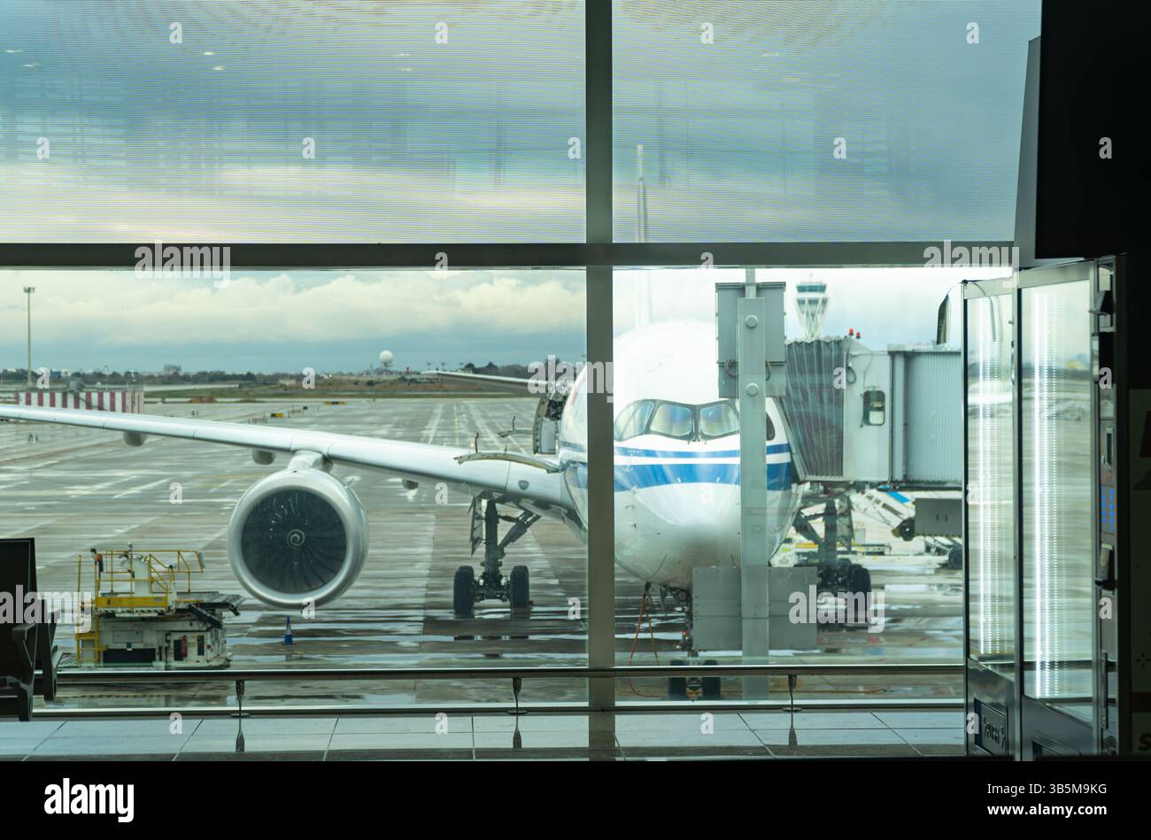 Un grande aereo è seduto sull'asfalto di un aeroporto. L'aereo è bianco e blu Foto Stock