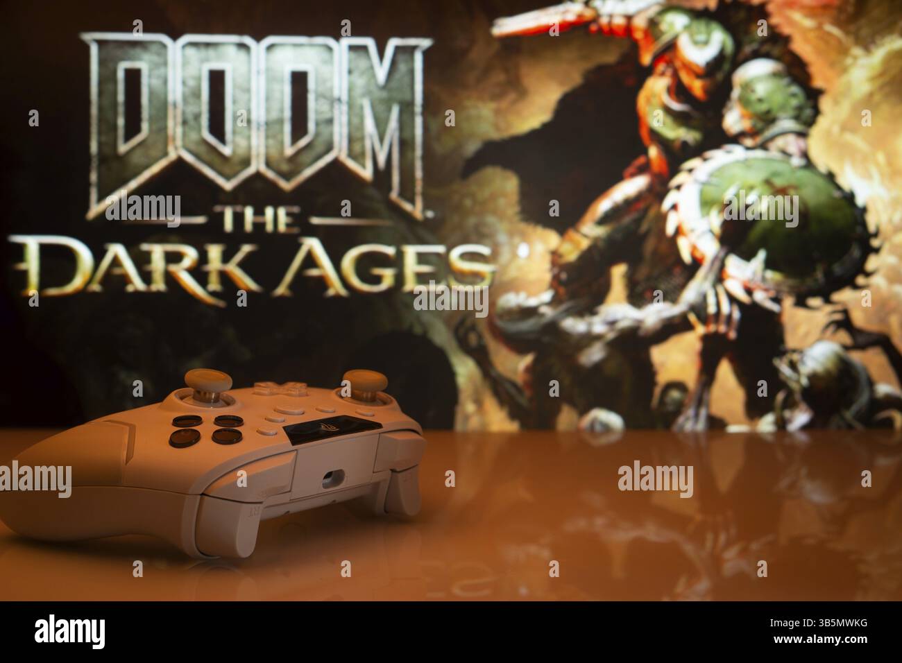 Dhaka, Bangladesh- 30 aprile 2025: Primo piano di un gamepad bianco con The Doom the Dark Ages visto sullo schermo sullo sfondo Foto Stock